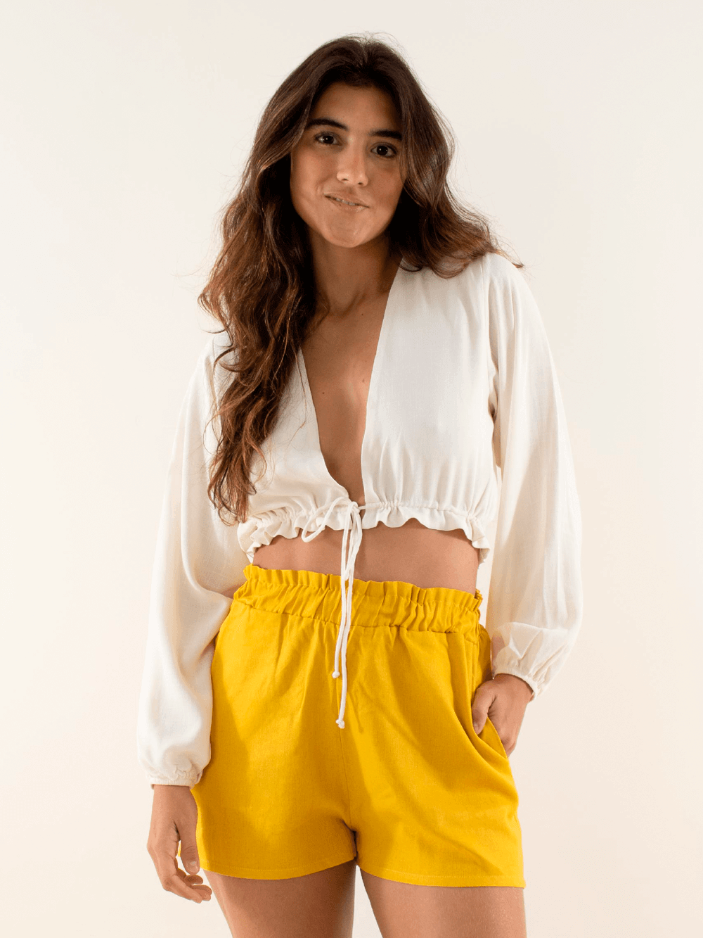 Short Elisa amarelo da marca Greenish, modelo feminino com blusa branca, look casual e moderno.