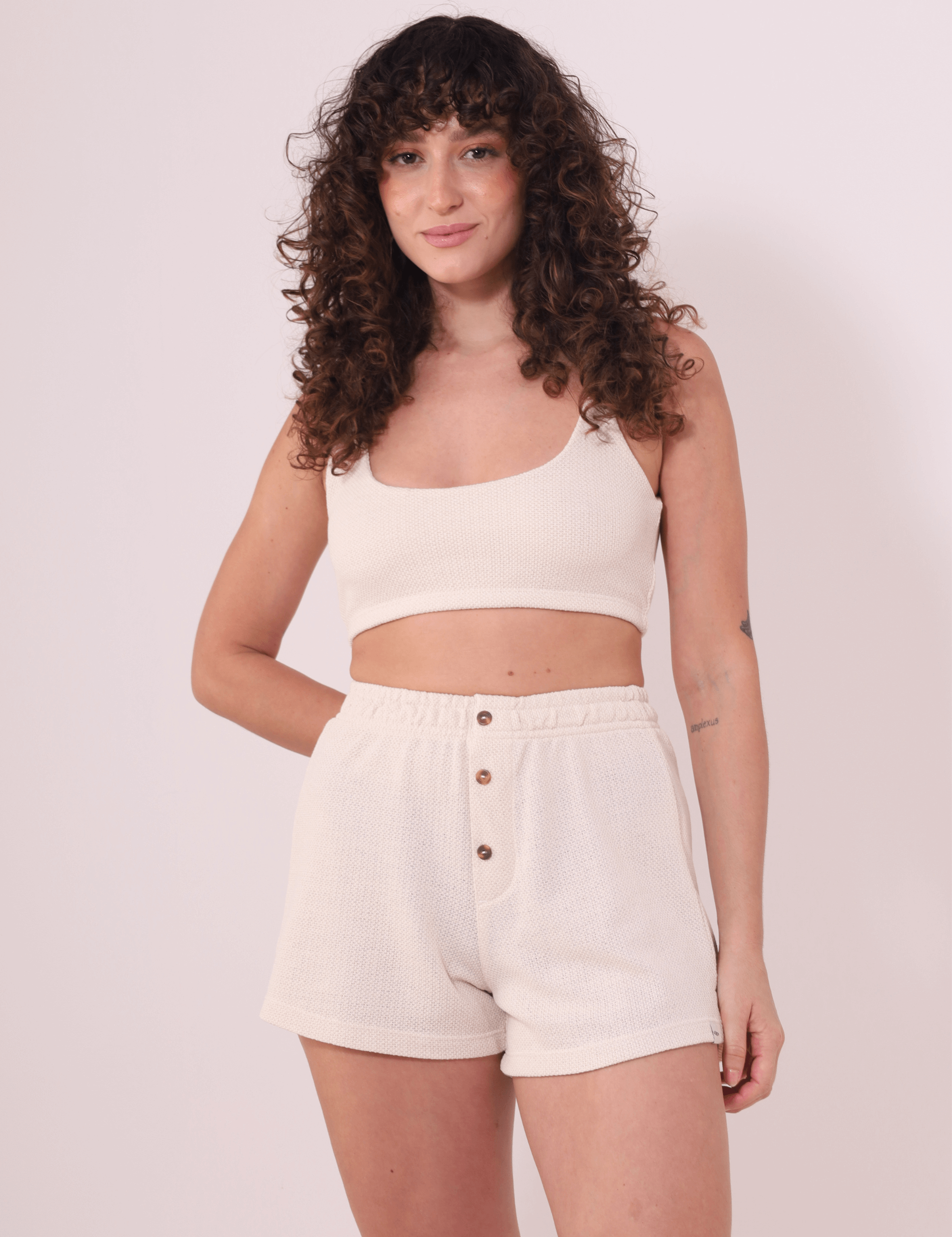 Short Malu Bege da Greenish com cintura alta e botões, modelo em pose casual exibindo conforto e estilo descomplicado.