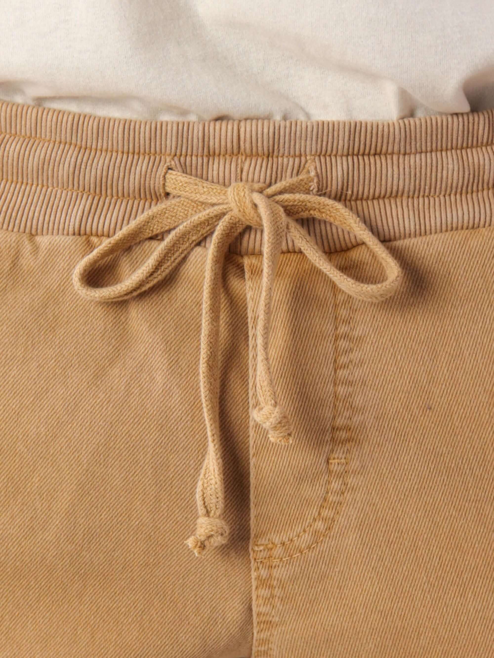 Detalhe do cadarço de algodão do Short Rio Stone - Amarelo da Greenish, ideal para conforto e estilo casual.