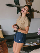 Short esportivo azul marinho da Greenish, perfeito para atividades e conforto, com modelo rindo e segurando um ukulele.