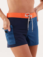 Shorts esportivos Talita da Greenish na cor azul marinho e laranja, ideais para atividades ao ar livre.