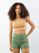 Modelo usando shorts vintage verde da marca Greenish, apresentando um estilo casual e moderno.