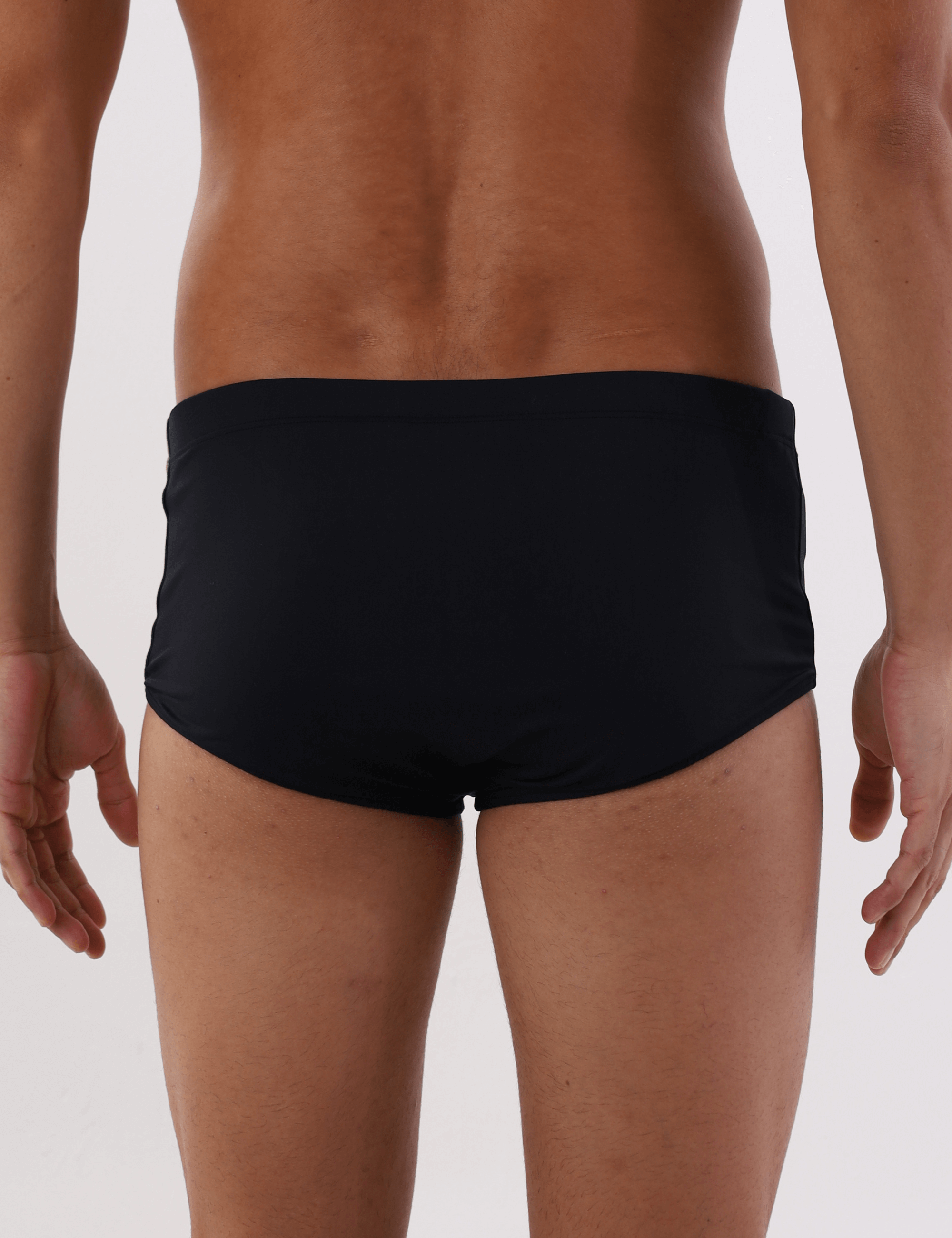 Modelo masculino vestindo sunga cavada preta básica Greenish. Vista traseira para mostrar o design confortável e ajustado.