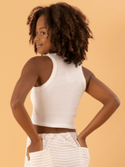 Top cropped básico em ribana off white da marca Greenish, ajustado e estiloso, exibindo costas e cabelo cacheado.