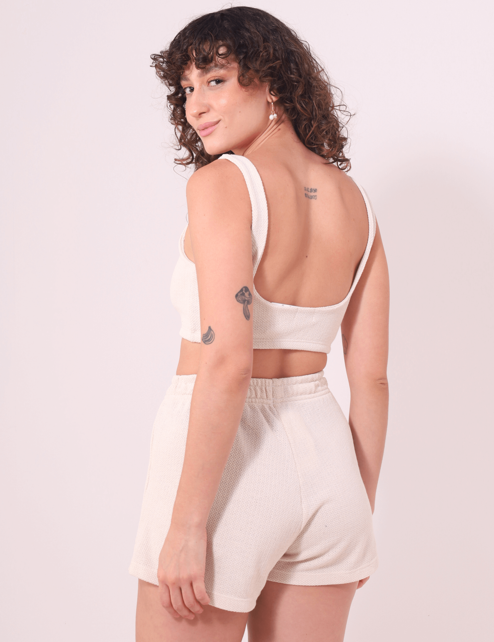 Modelo usando Top Nalu Bege da Greenish, com design leve e confortável, ideal para looks descontraídos e monocromáticos.