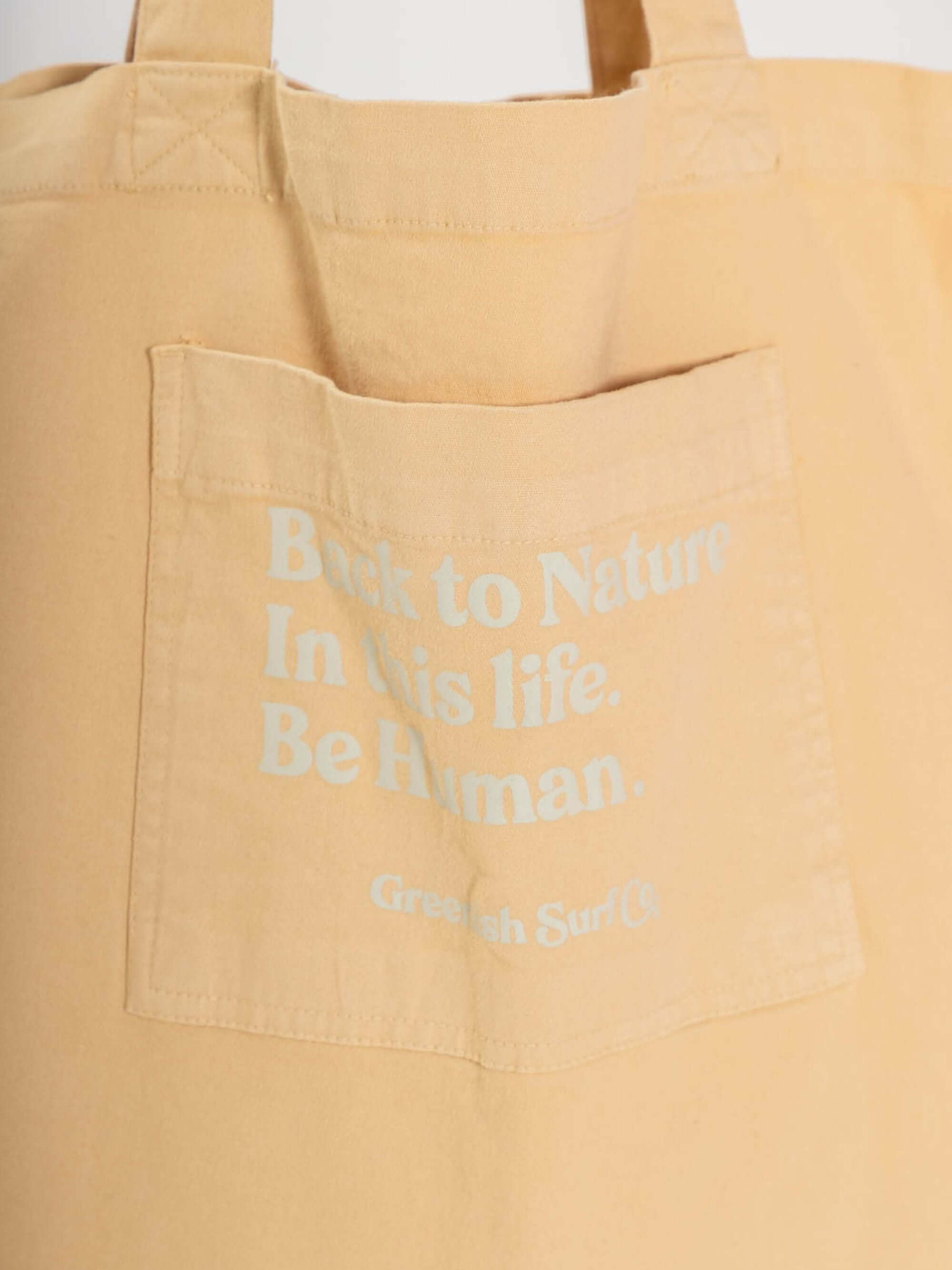 Tote bag amarela da Greenish com estampa "Back to Nature" no bolso, ideal para estilo moderno e conforto.