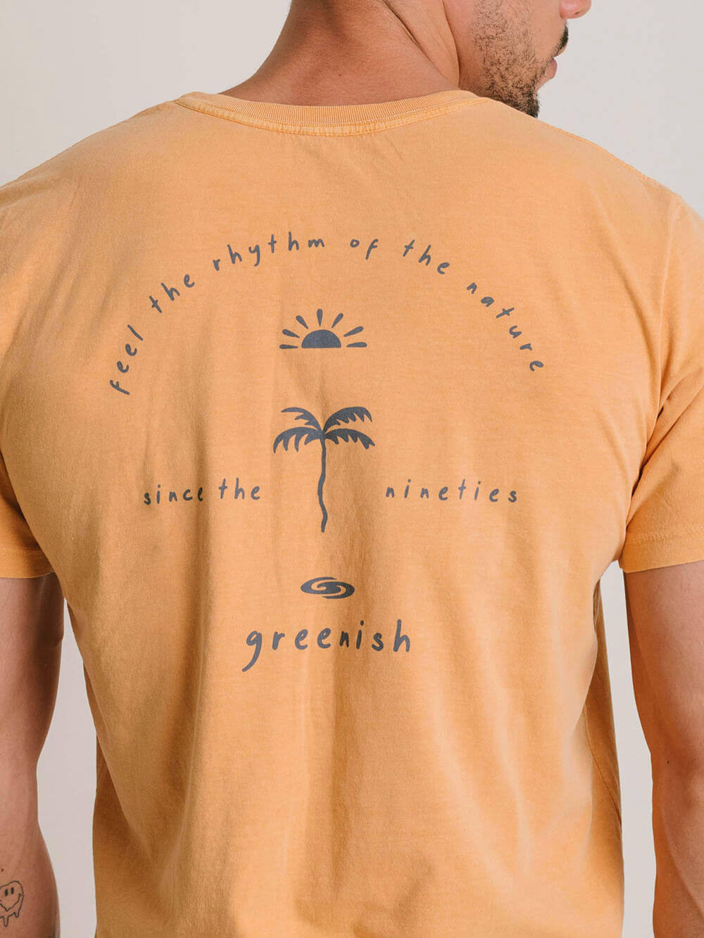 Camiseta vintage Greenish amarela com estampa de sol e palmeira, trazendo a essência do ritmo natural.