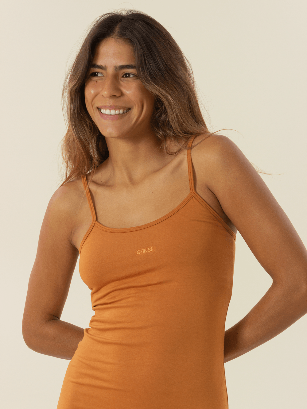 Modelo sorrindo com vestido curto comfy basic da Greenish na cor marrom, ideal para conforto e versatilidade.