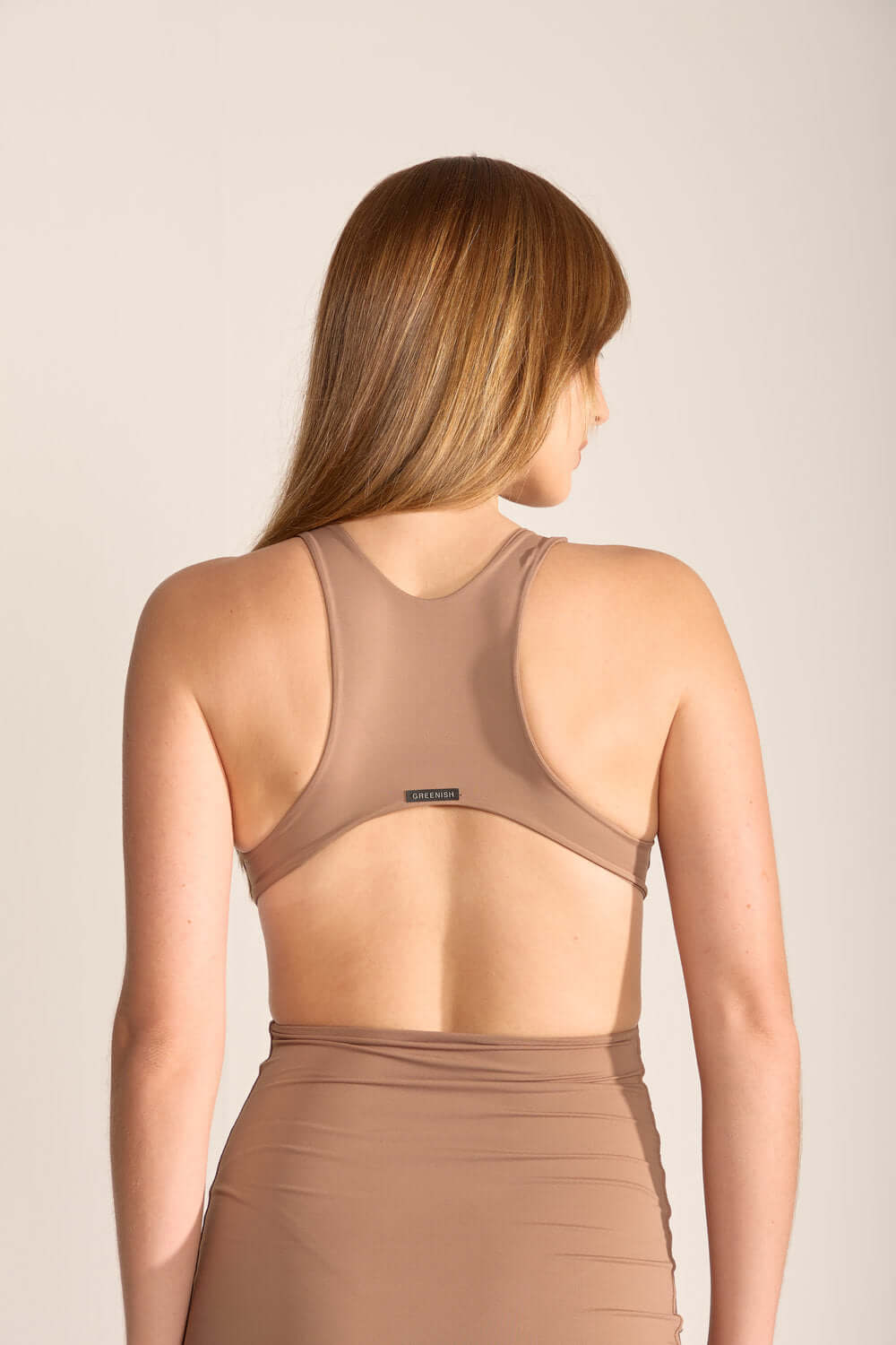 Modelo de vestido curto Gigi da Greenish, vista traseira com decote nadador em tom camurça.