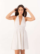 Vestido curto Lucky da Greenish, em off white, com decote em V e amarração, ideal para looks delicados e práticos.
