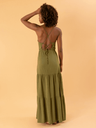 Modelo feminina usando vestido longo Lina verde da marca Greenish, com detalhes de amarração nas costas.