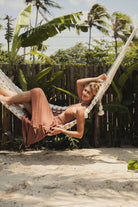 Vestido Midi Riviera - Cacau da Greenish relaxando em uma rede ao ar livre, ideal para dias ensolarados e férias. Conforto e estilo.