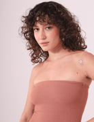 Modelo vestindo vestido canelado sem alças em tom cacau, destacando o sol na tatuagem e elegância casual. Marca: Greenish.