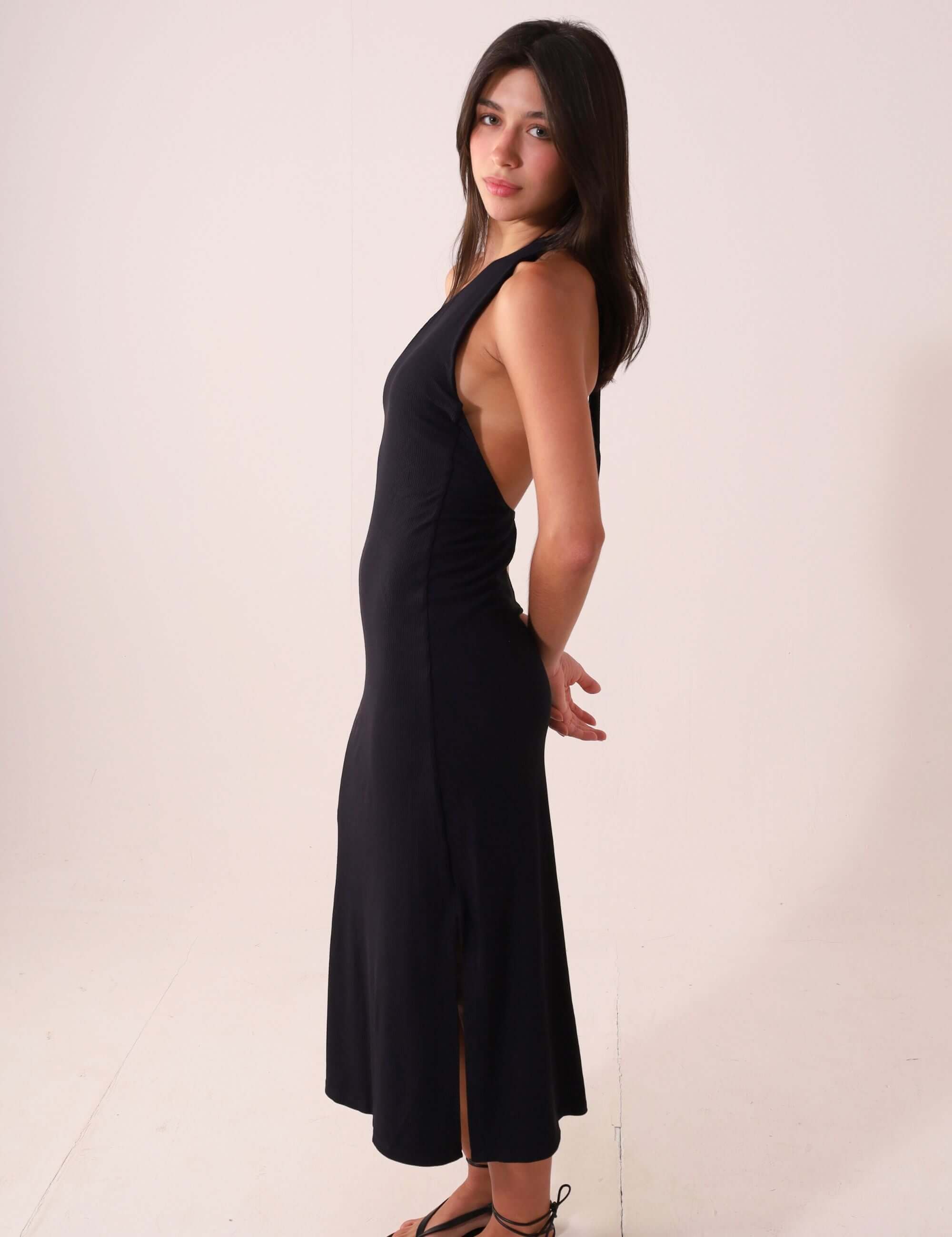 Mulher vestindo Vestido Monique - Preto, modelagem midi com design de um ombro só, destacando a silhueta com elegância e sofisticação.