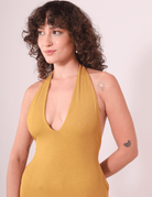 Modelo usando Vestido Longo Serena - Caqui da Greenish com decote profundo e faixas para amarração, destacando leveza e charme.